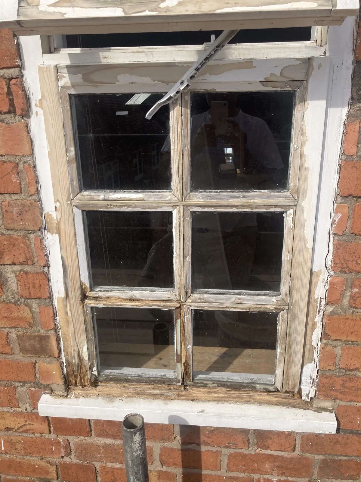 Sash window with damaged and peeling timber before restoration